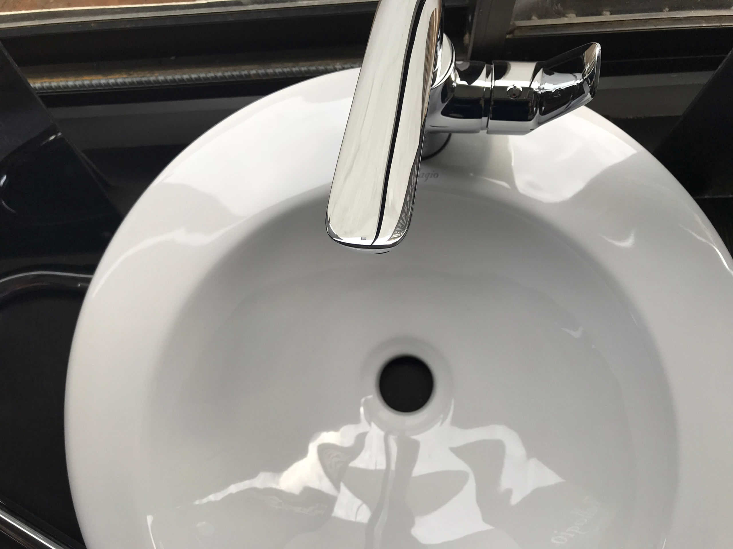 White ceramic sink with a stainless steel faucet