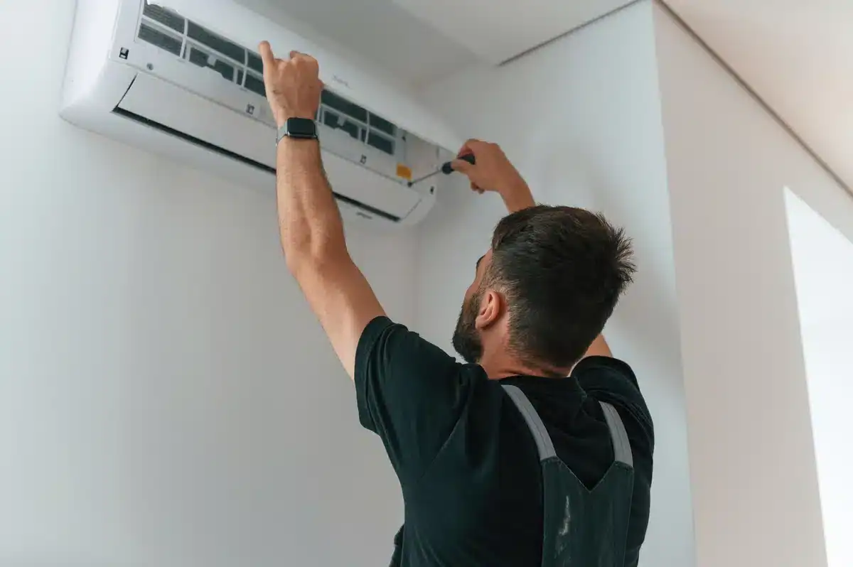 worker repairs air conditioner indoor