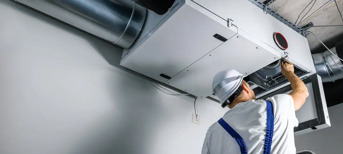 man installing heat recovery ventilation system