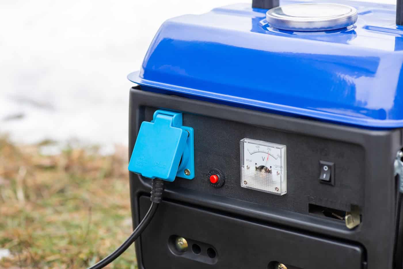 Close Up Of Working Gasoline Generator With Plugged In Socket. Portable Electric Generator Working Outdoors In Winter, Supplying House With Energy And Heating It
