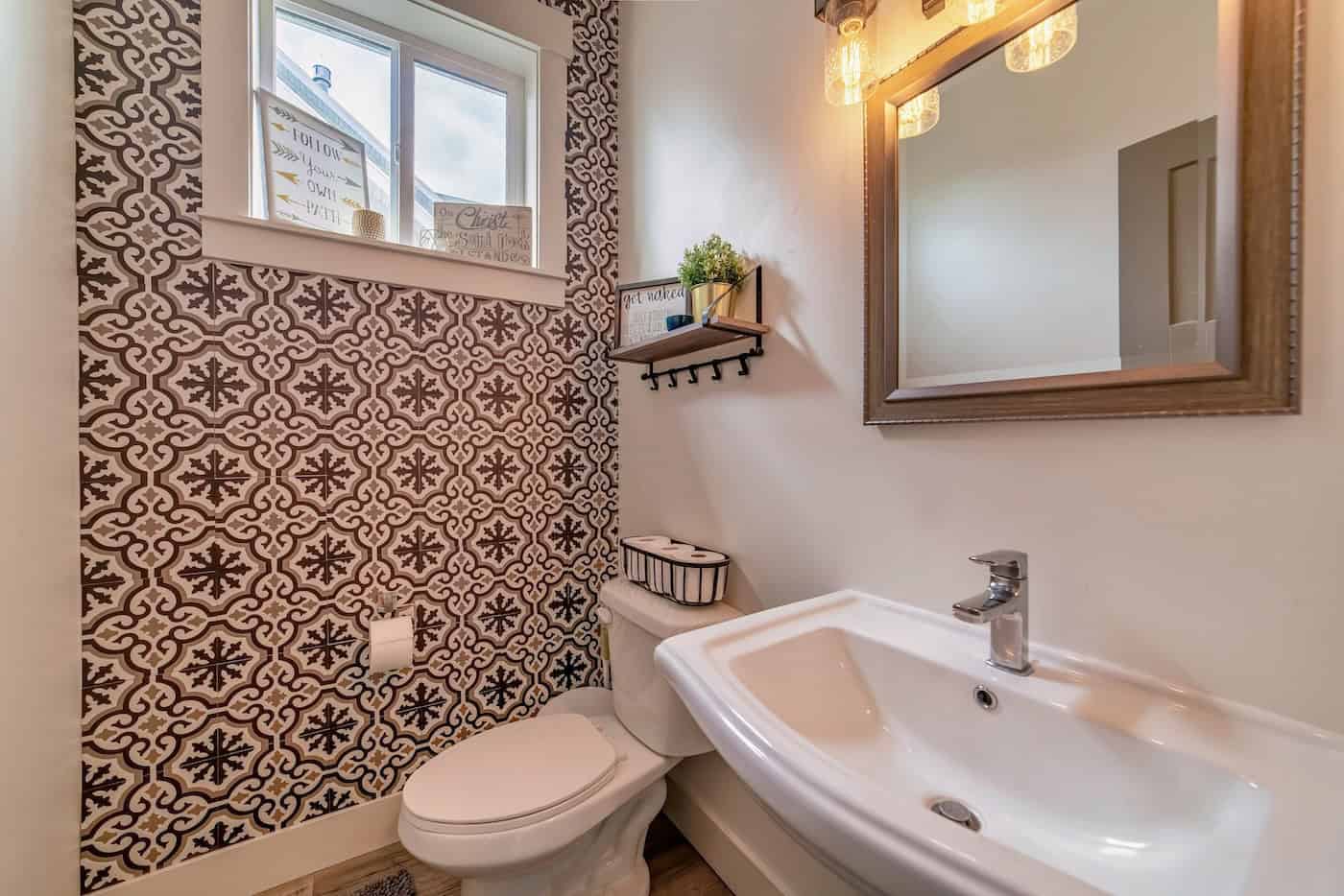Sink Toilet And Mirror Inside Residential Bathroom With Decorative Accent Wall