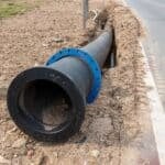 Construction Site With New Water Pipes In The Ground. Sewer Pipes To Repair Or Restore In Street City