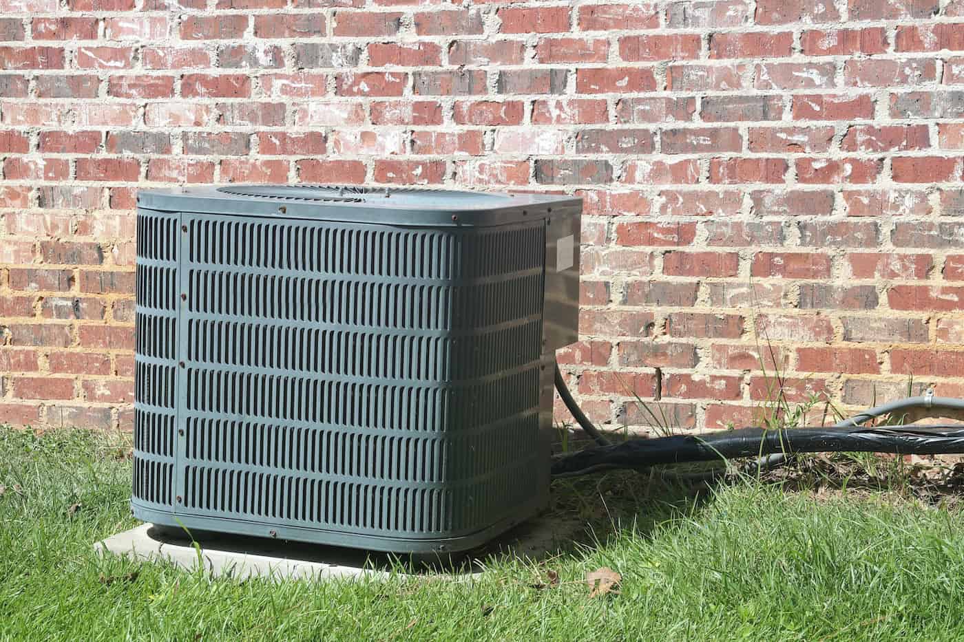 Home Air Conditioner Compressor Condenser Coil In Front Of Brick Wall