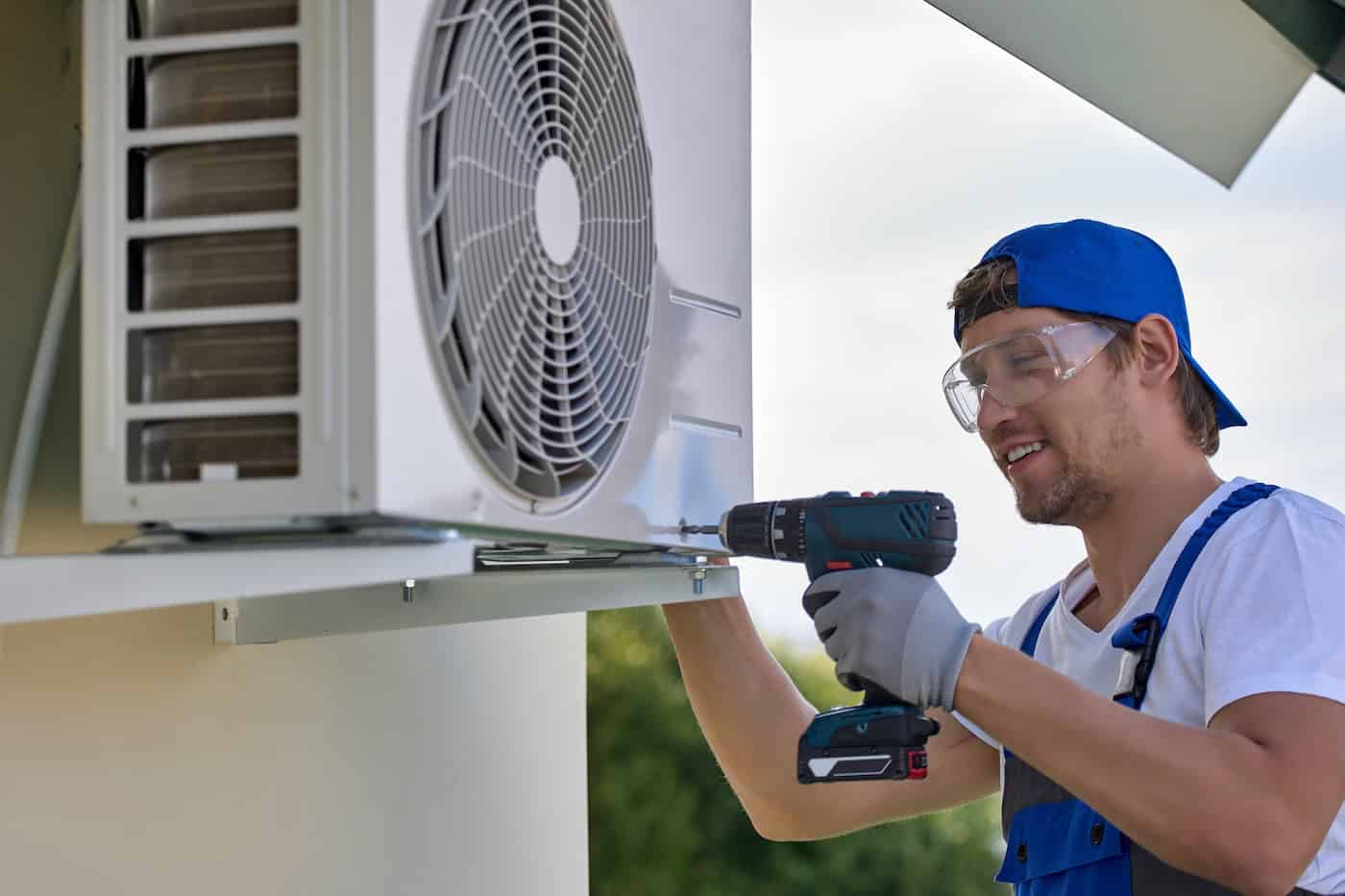 Caucasian Worker Installs Outer Metal Case Air Conditioner With Screwdriver