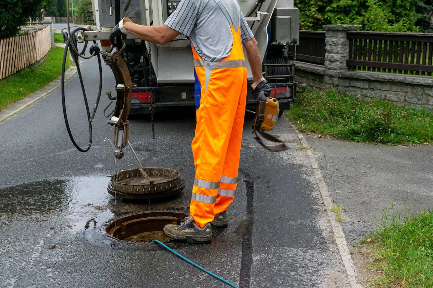 Sewerage Worker On Street Cleaning Pipe