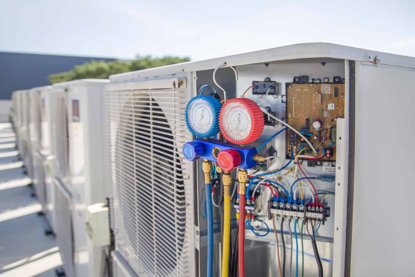 Air Conditioning, Hvac Service Technician Using Gauges To Check Refrigerant And Add Refrigerant.