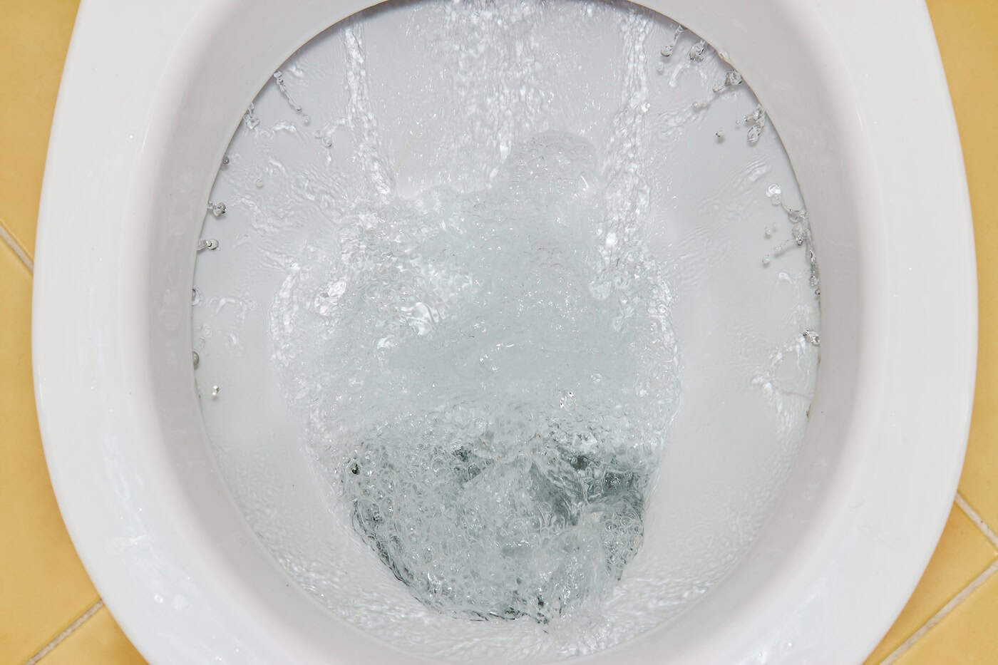 View Of A Flushing White Toilet