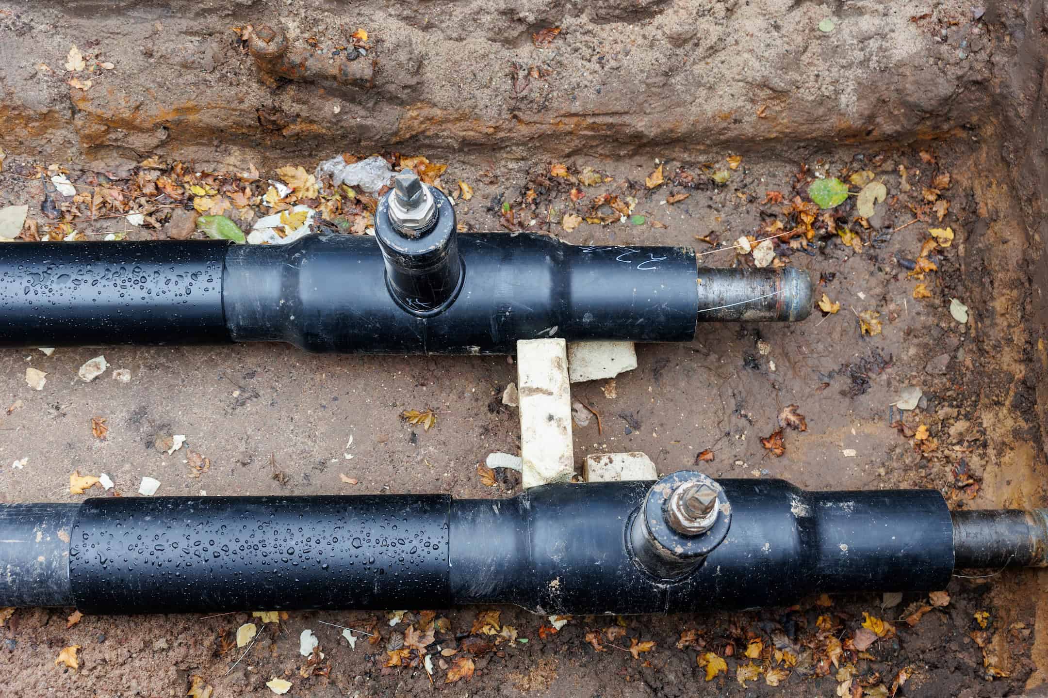 New Modern Insulated Urban Pipeline Installation Construction Site Exposed Underground Pipes In Shored Trenches. Insulated Steel Pipes Lie Connection Engineering Infrastructure Upgrade Work