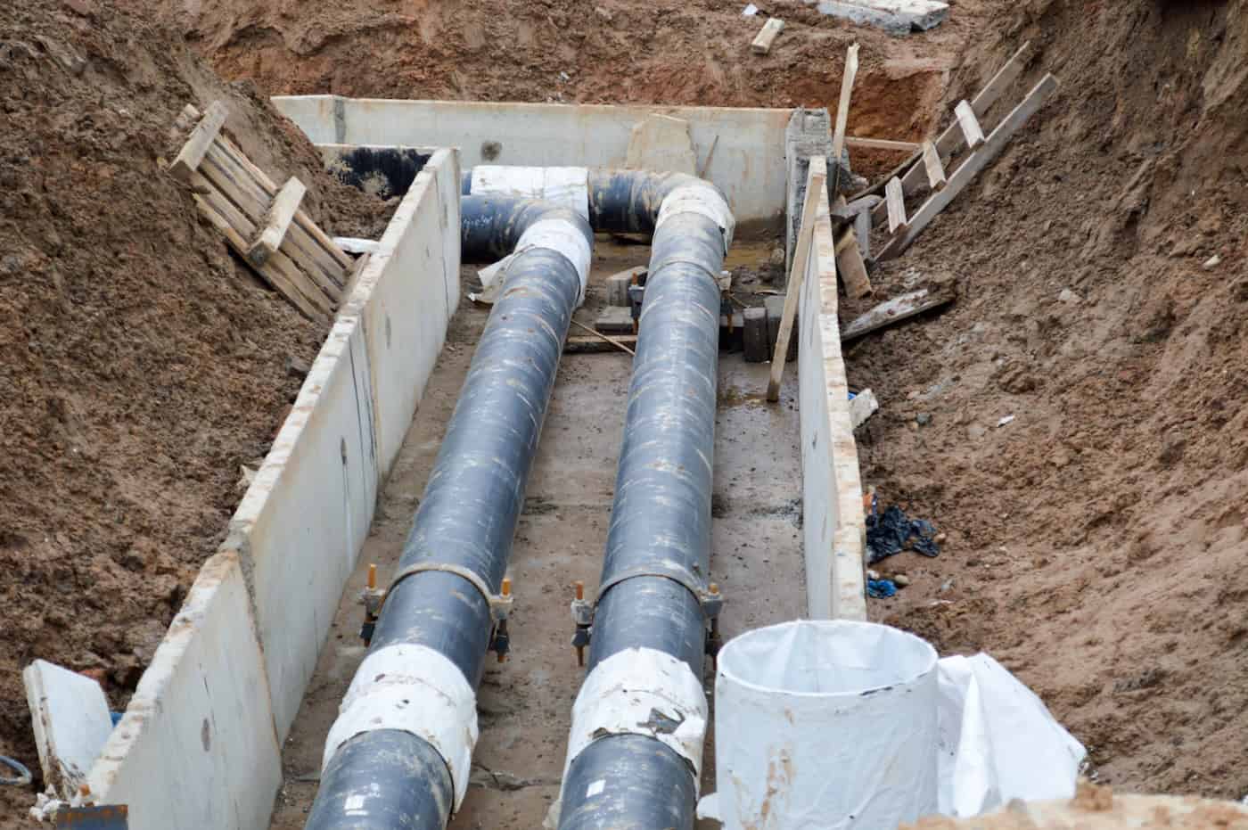 Large Black Metal And Plastic Water Pipes For Hot And Cold Water At A Construction Site During A Repair In A New Neighborhood Under The Ground