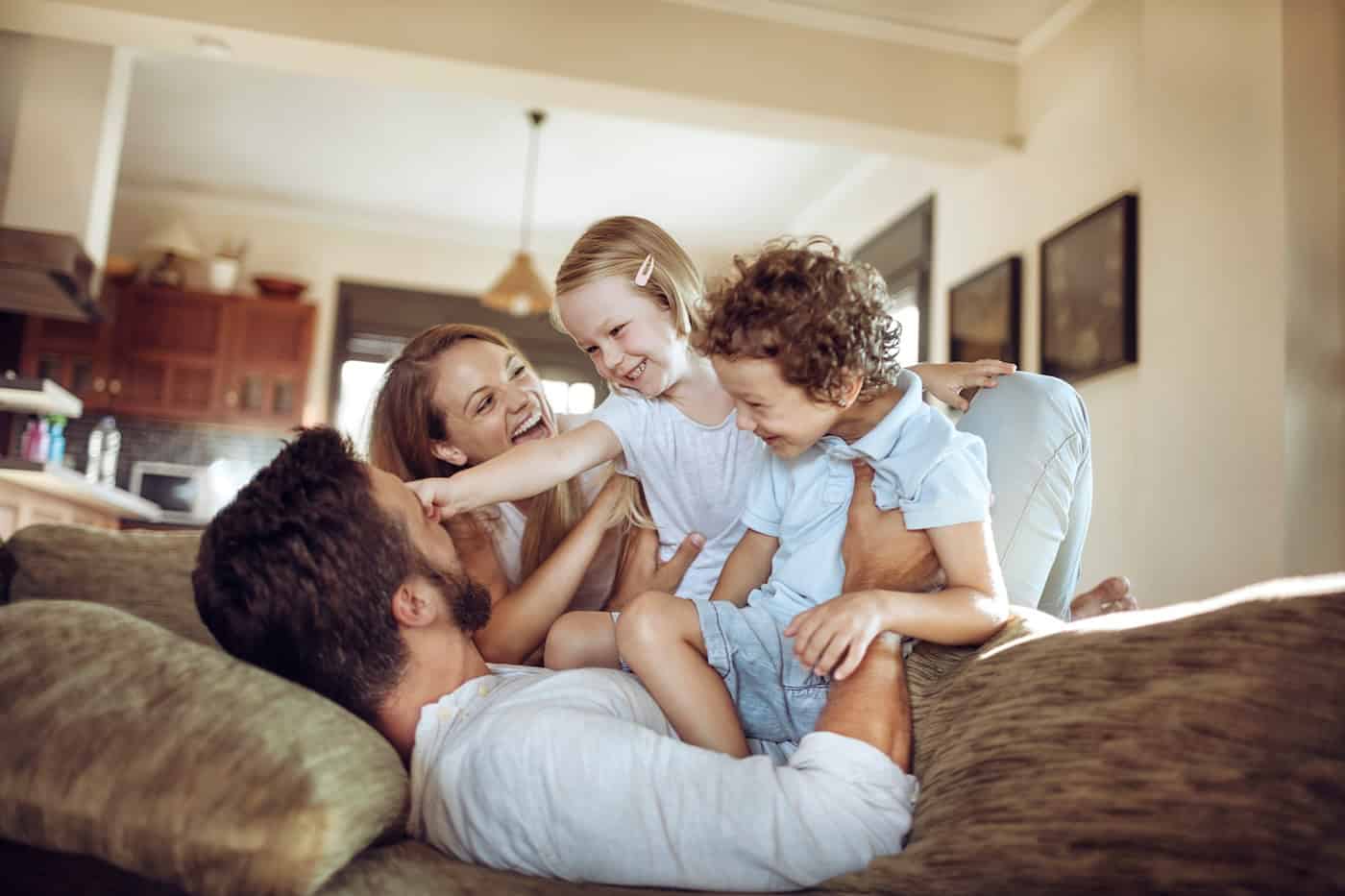 Joyful Family Sharing A Playful Moment In Their Living Room