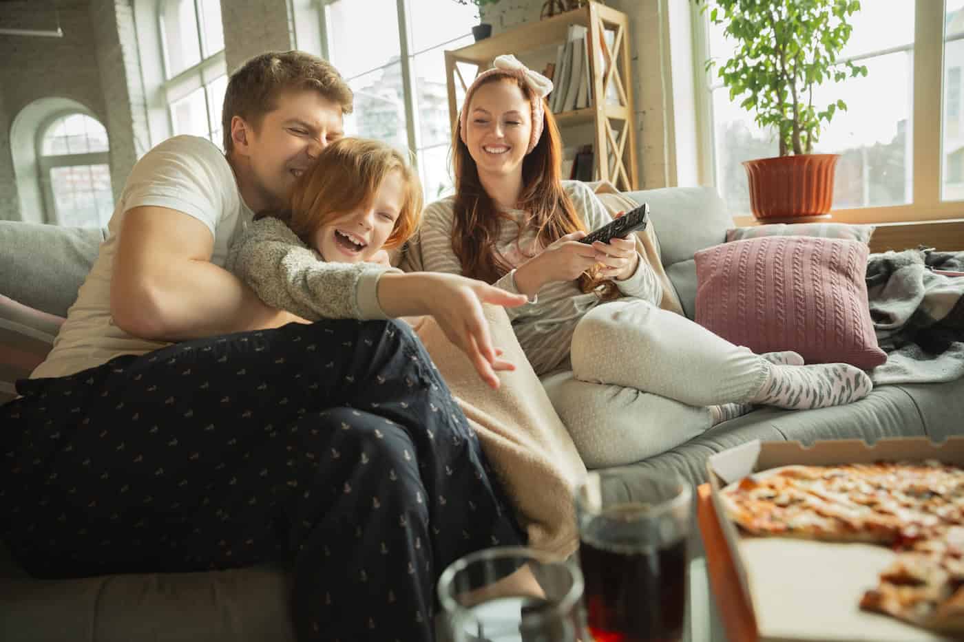 Family Spending Nice Time Together At Home, Looks Happy And Cheerful, Eating Pizza