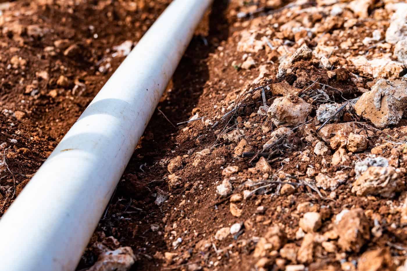 Pvc Pipe In Dirt Trench Outdoors For Plumbing Water Drainage Installation. Underground Irrigation System.