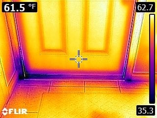 Thermal image of a door showing cooler temperatures (blue/purple) around the bottom edges and warmer areas (yellow/orange) on the door, indicating possible air leakage near the floor. Temperature readings are displayed.
