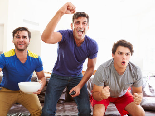 Men celebrating a win from watching tv