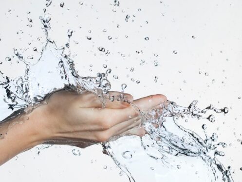 Hands holding splashing water