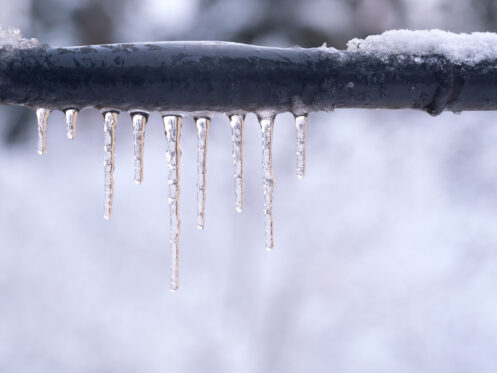 Frozen pipe with icicles hanging off of it