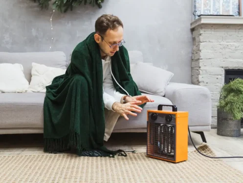 man-warming-up-with-electric-heater
